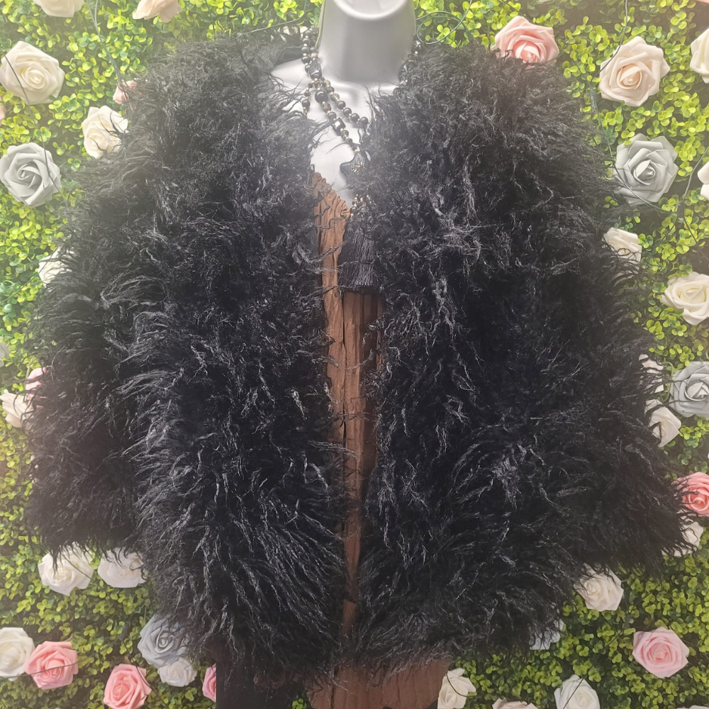 Black fluffy coat on a mannequin against a floral background