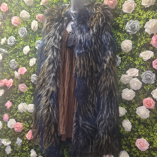 Faux Fur Gilet in blue, grey and tan on a mannequin in front of a greenery wall