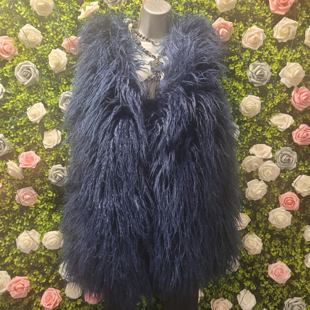 Faux Fur Shaggy Gilet on a mannequin in front of a greenery floral wall