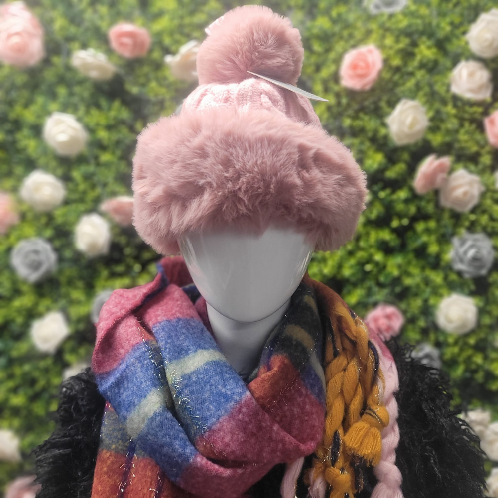 Chunky Knit bobble hat in pink with faux fur trim on a greenery and floral backdrop