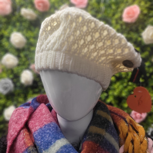 Mannequin wearing a textured beige beanie with a colorful scarf against a floral background