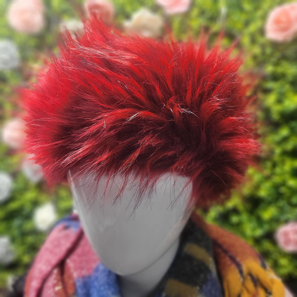 Mannequin head with a red furry hat against a blurred floral background