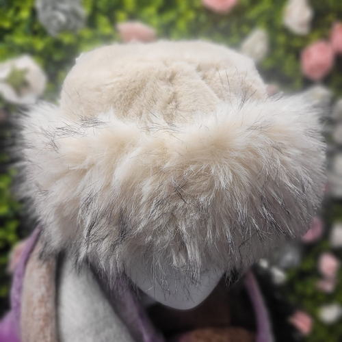 Close-up of a fluffy white hood with a blurred floral background
