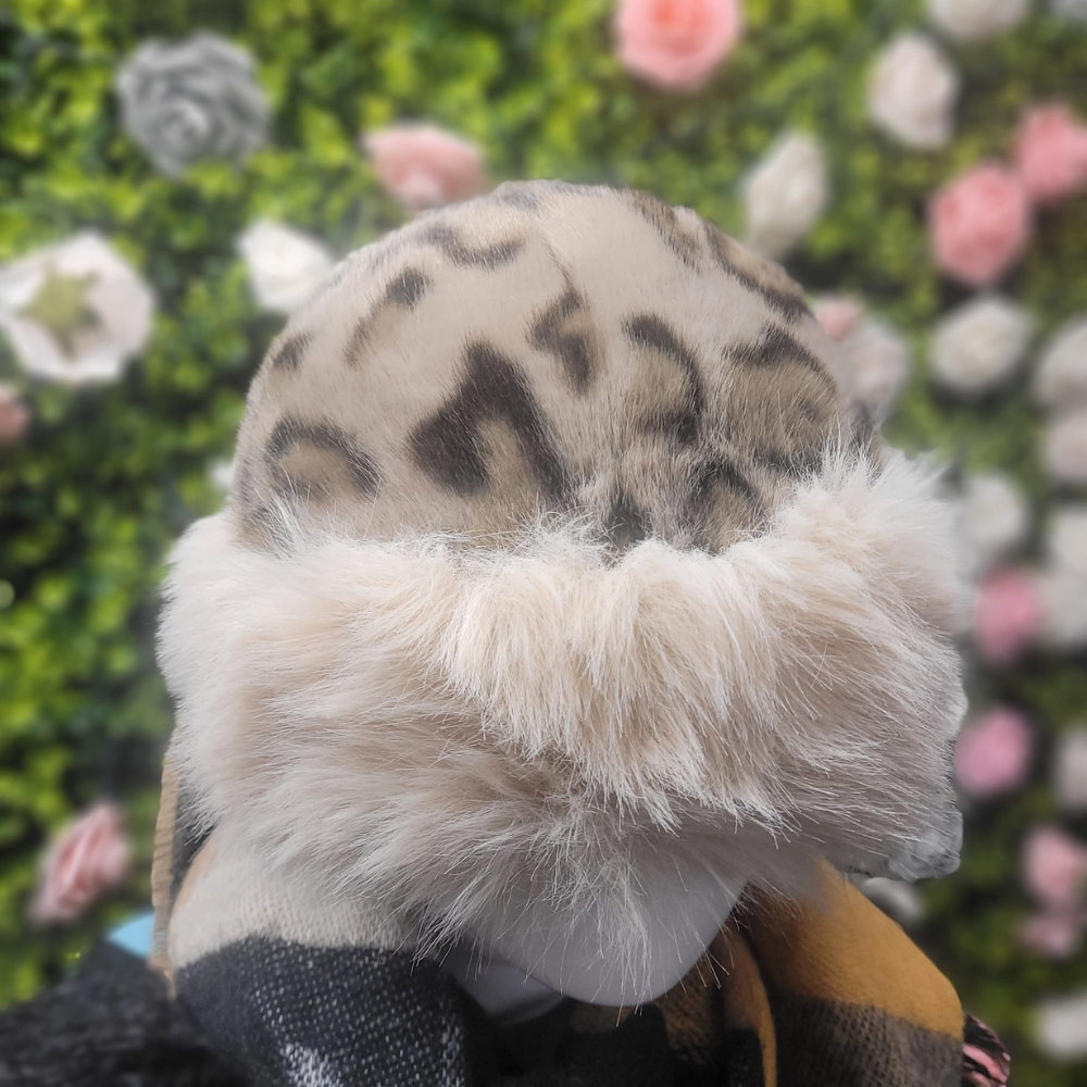 Close-up of a plush hat with a leopard print head against a floral background