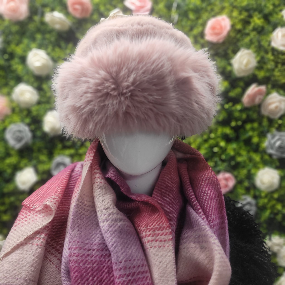 Mannequin wearing a pink fur hat and scarf with a floral background