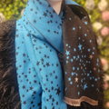 Blue and black scarf with star pattern on a blurred natural background