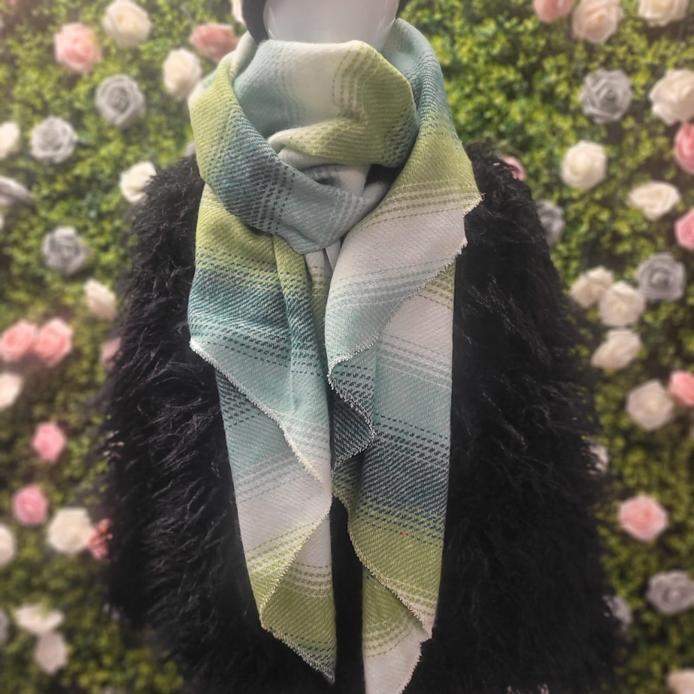 Scarf with a gradient pattern draped over a black garment against a floral background