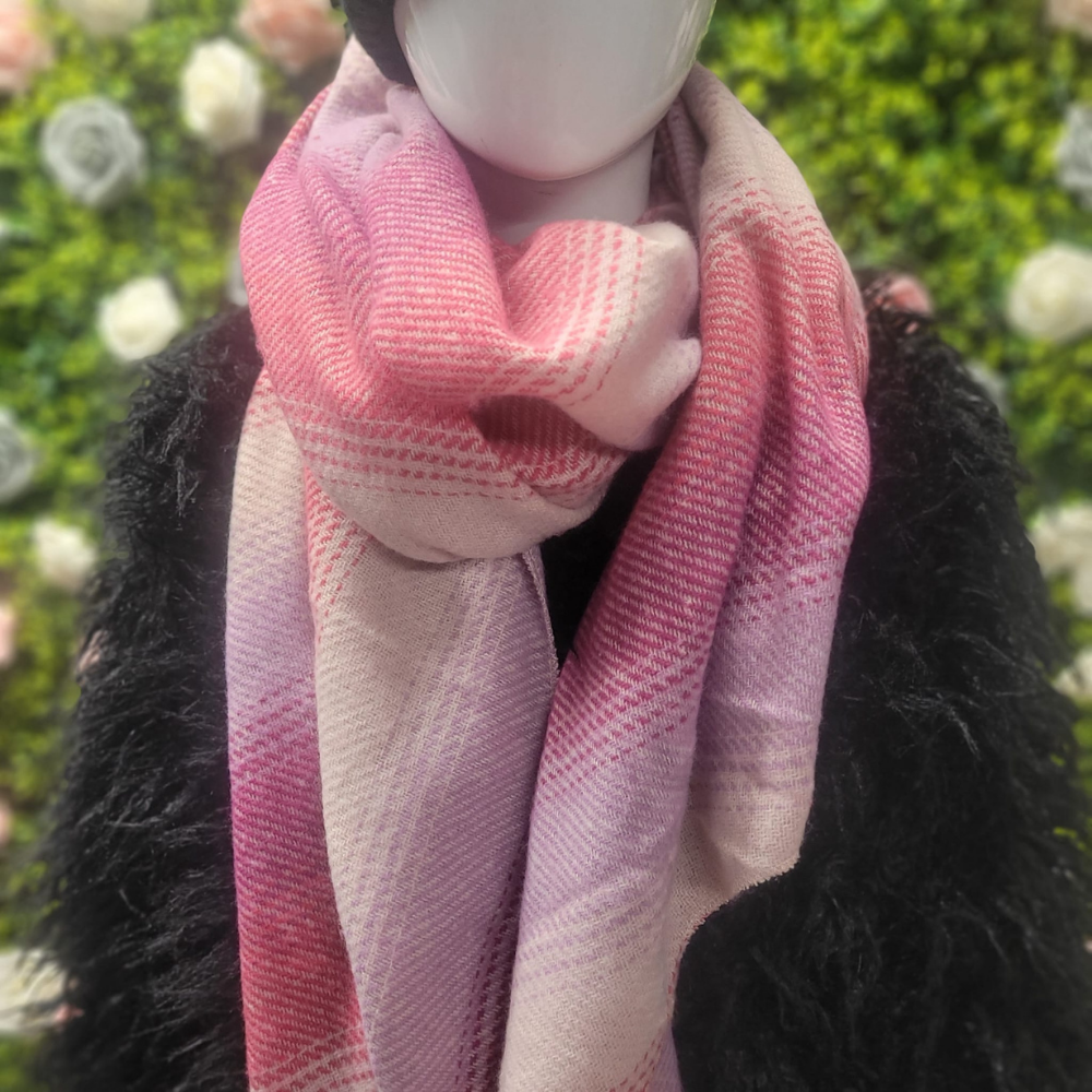 Mannequin wearing a pink and purple scarf with a blurred green and white background
