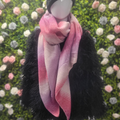 Mannequin wearing a pink scarf with a floral background