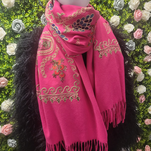 Pink embroidered scarf on a mannequin against a floral background