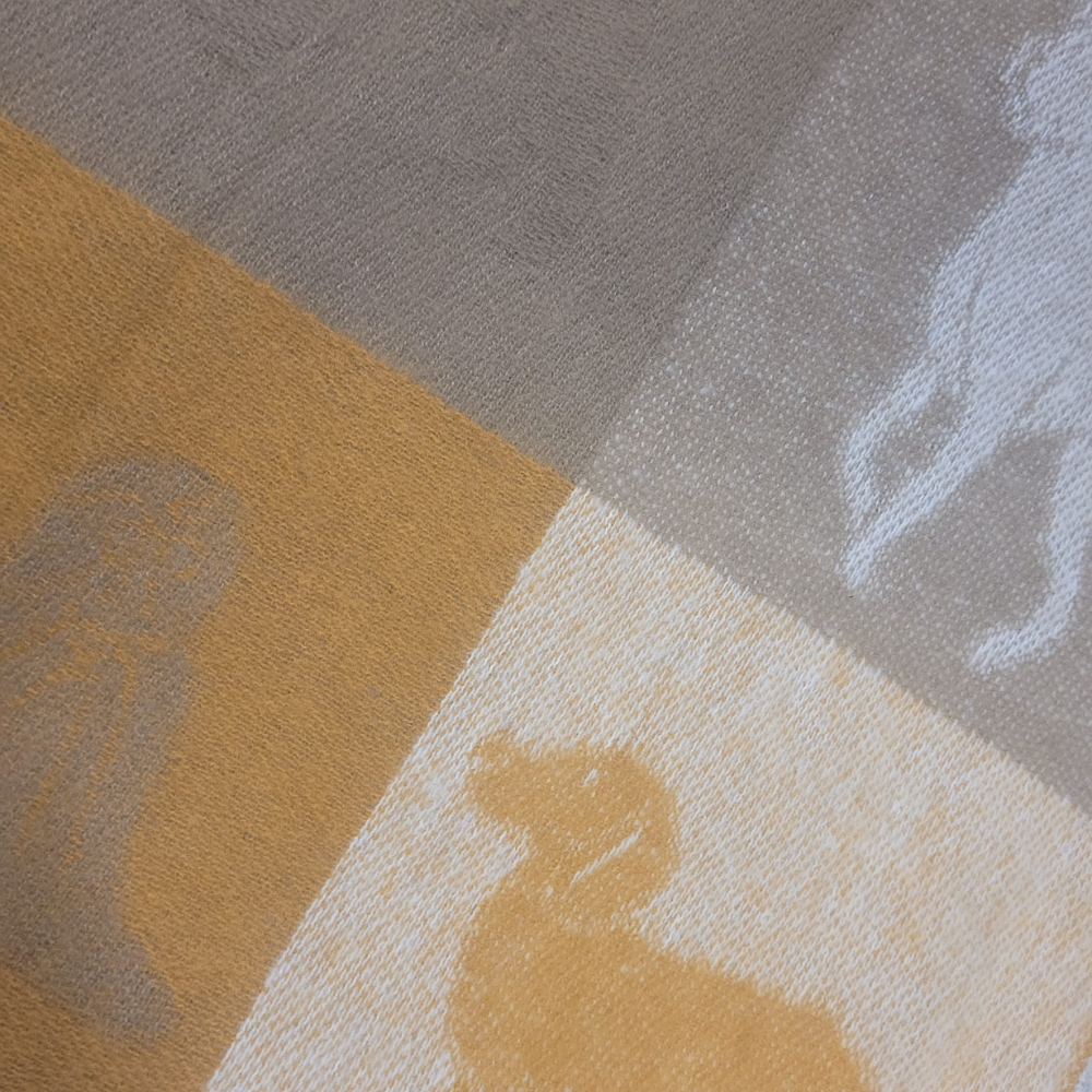 Close-up of a textured fabric with animal patterns in brown, gray, and beige.
