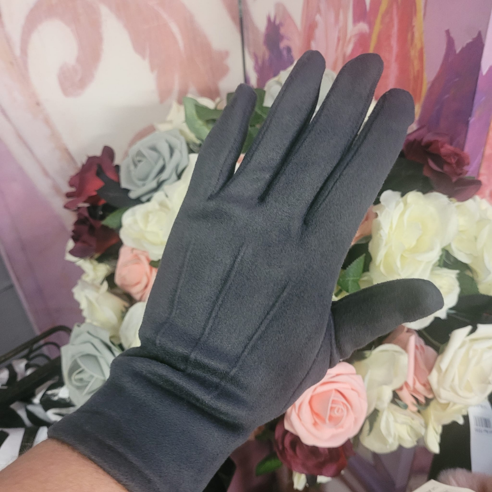 Black glove held against a floral background