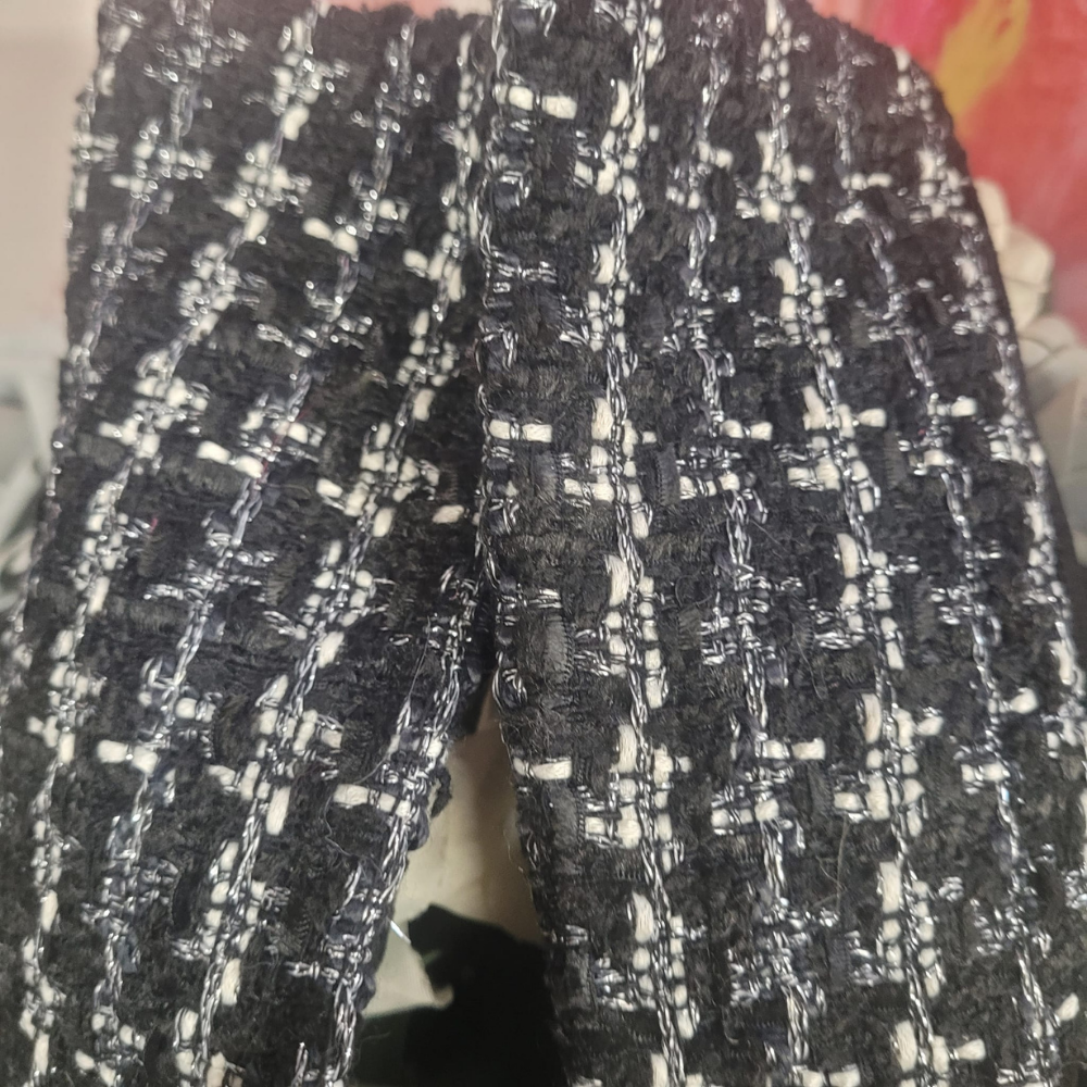 Black and white patterned fabric gloves with a blurred background