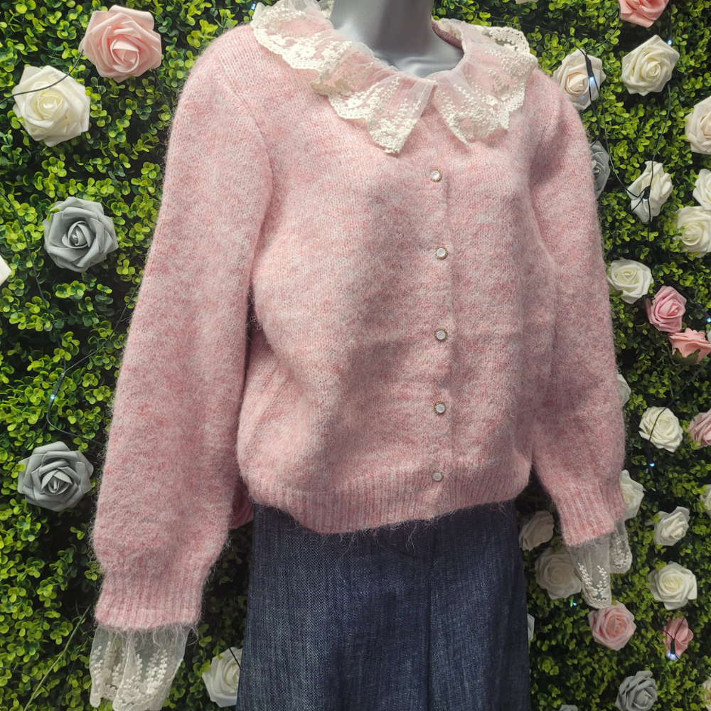Pink sweater with lace collar on a mannequin against a floral background