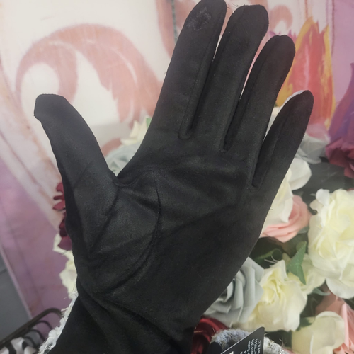 Black glove held up against a floral background