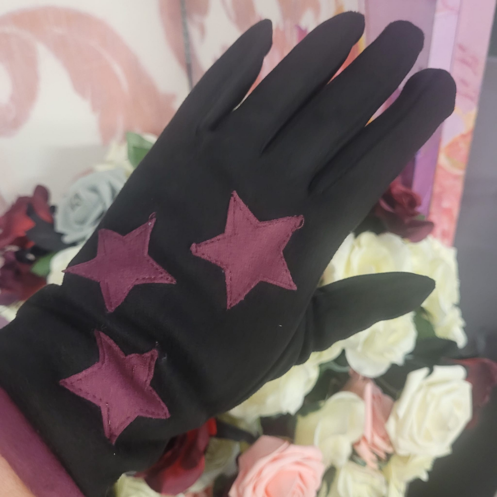 Black glove with pink stars on a floral background