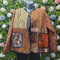 Patchwork jacket on a mannequin against a floral and green background