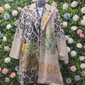 Two jackets with leopard print and floral designs on a mannequin against a floral and green background.