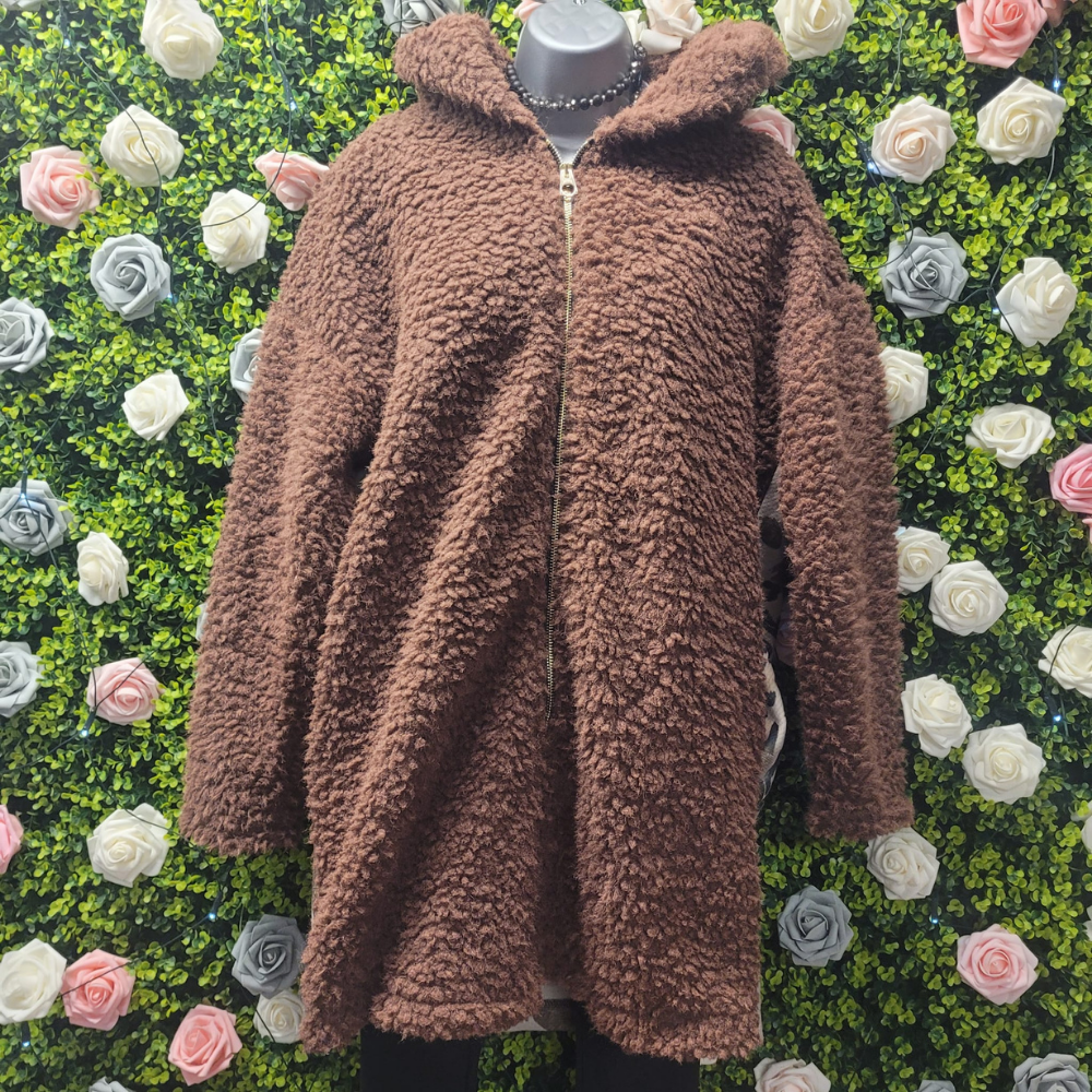 Brown collared boucle jacket on a greenery wall backdrop