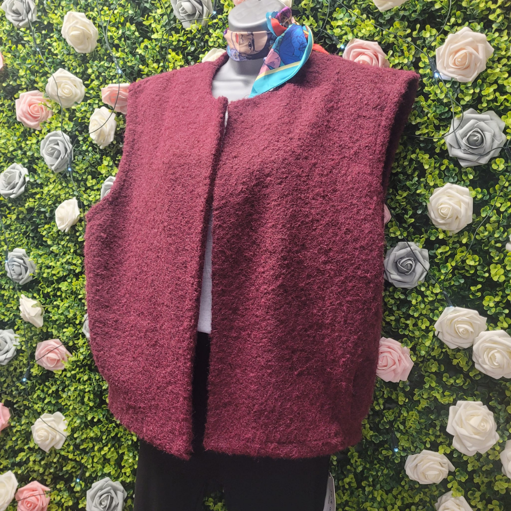 Maroon fleece vest on a mannequin against a floral background