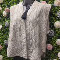 Quilted vest on a mannequin against a floral and greenery background