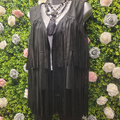 Black tasseled Gilet on a greenery wall backdrop