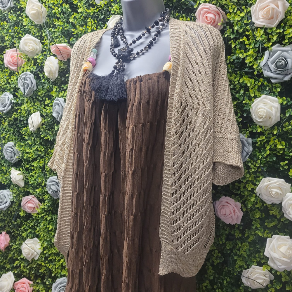 Gold cardigan shrug on a mannequin on a greenery backdrop