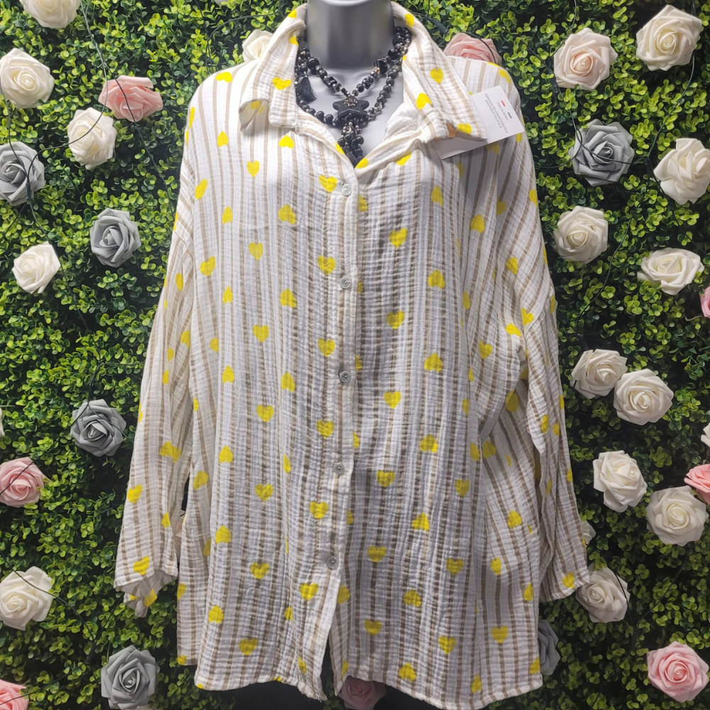 White shirt with yellow patterns on a mannequin against a floral background