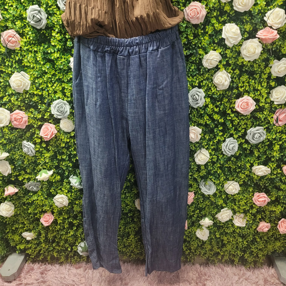 Blue pants displayed against a green wall with floral decorations