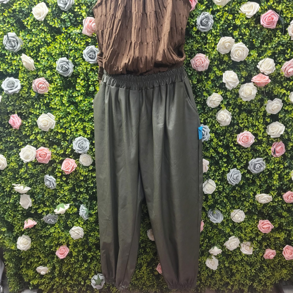 Khaki harem pants on a mannequin with a greenery backdrop
