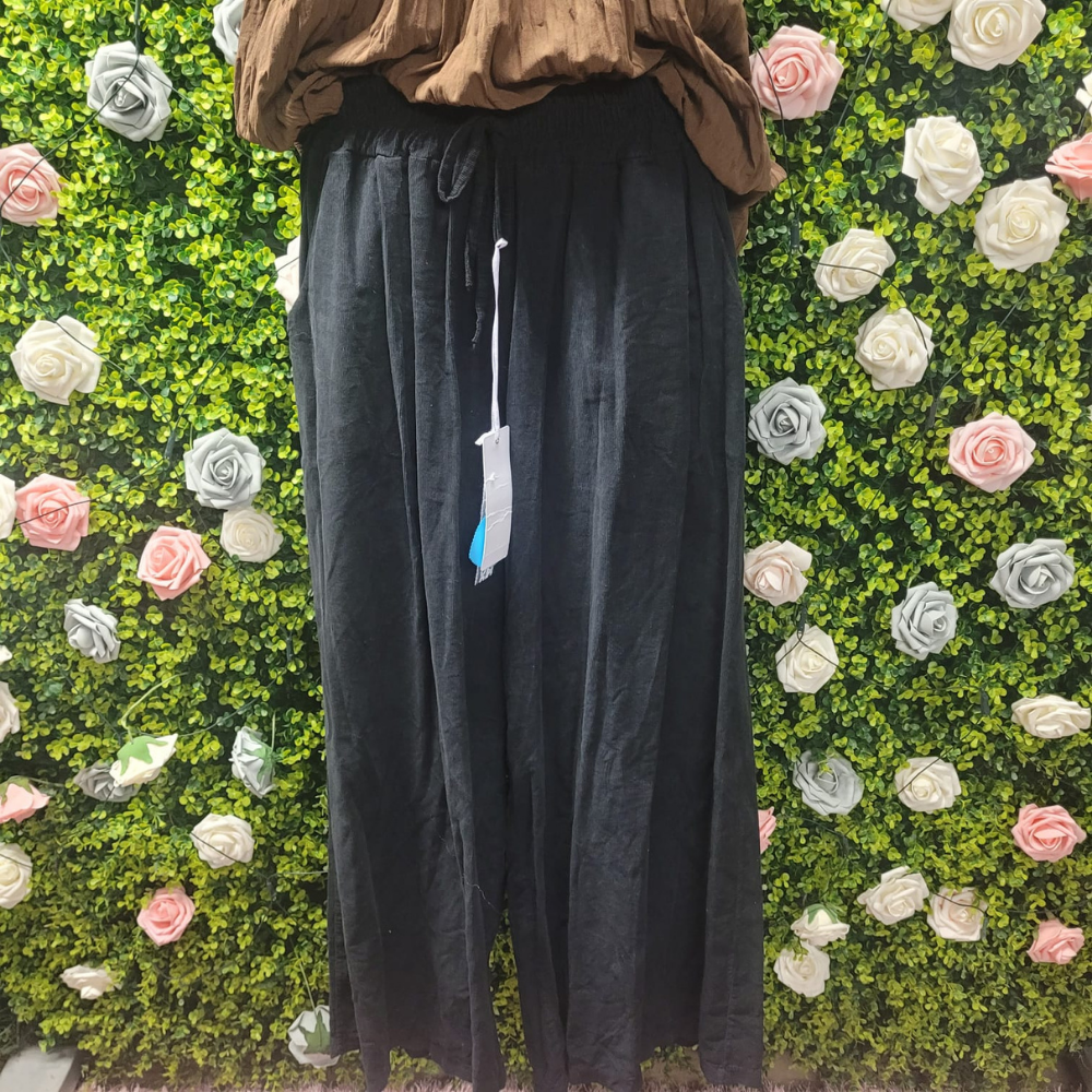 Black wide leg coords on a mannequin with a greenery backdrop
