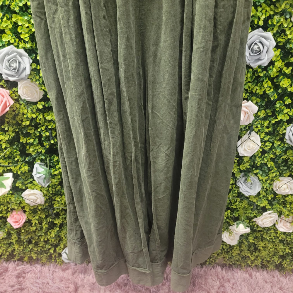 Olive cord pant on a mannequin with a greenery backdrop