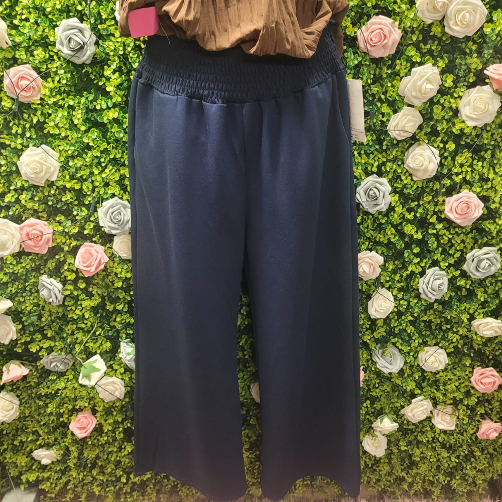 Blue jeans wide legged on a mannequin and a greenery backdrop behind